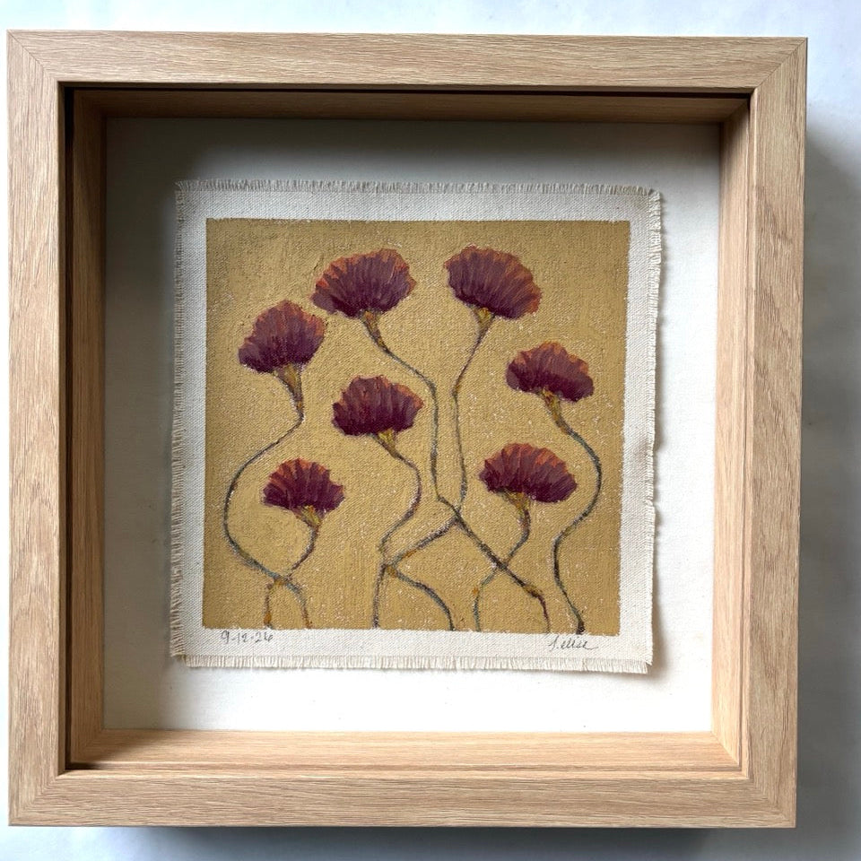A framed art print featuring five dark burgundy dried flower heads on a textured beige background, housed in a light oak shadow box frame with a white mat.